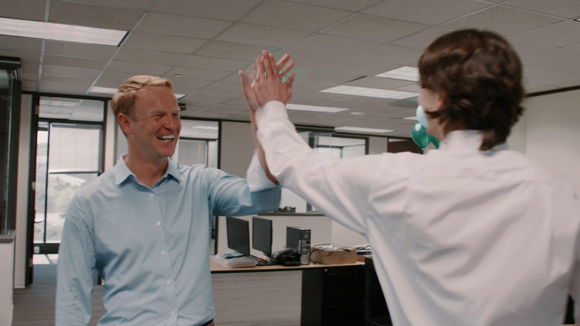 Two Bridgepoint colleagues high-fiving in the Bridgepoint office